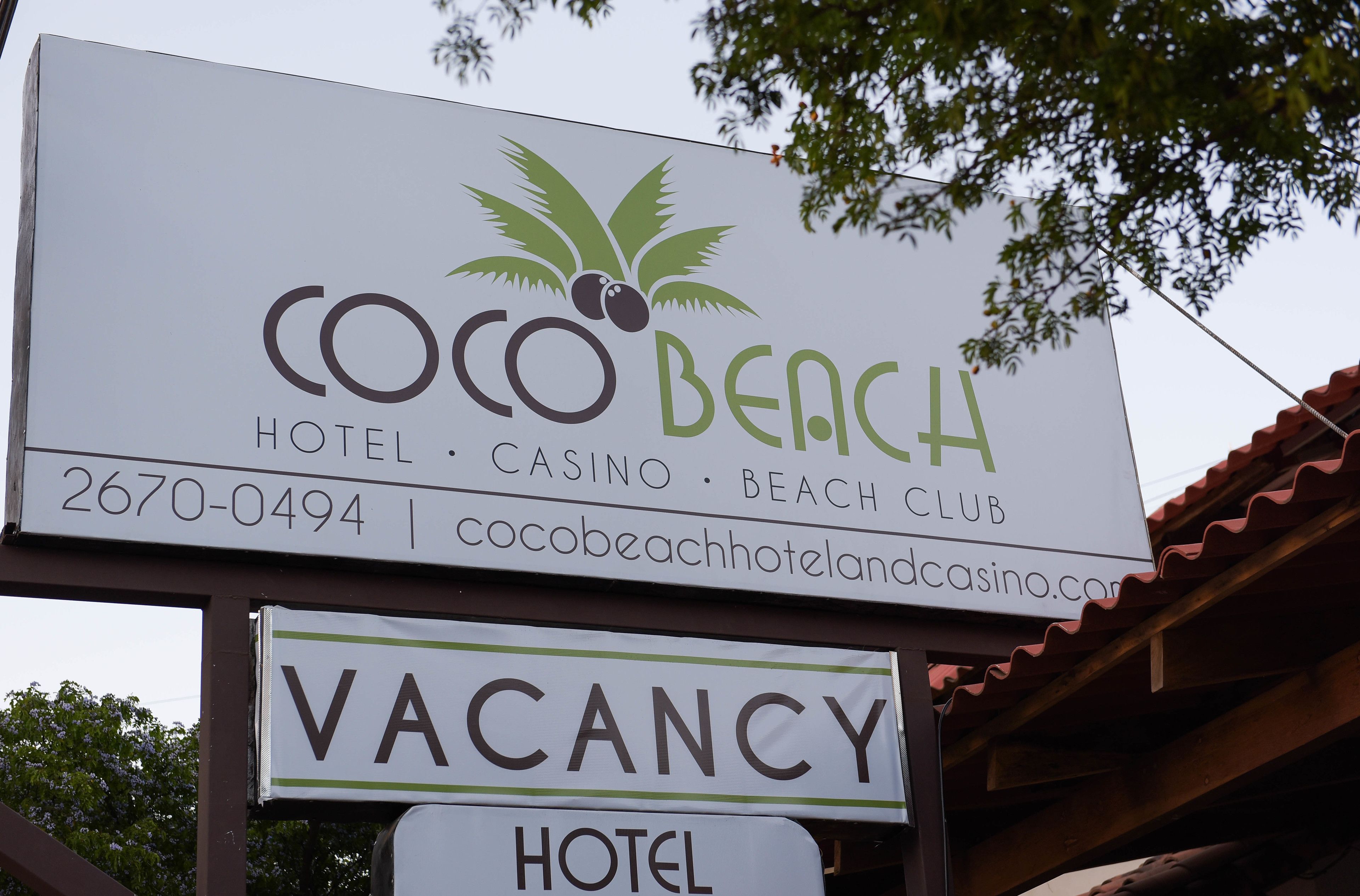 A hotel sign with the name "Coco Beach Hotel" and a palm tree logo.