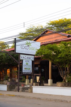 A hotel sign with "Coco Beach" and "VACANCY" indicating available rooms.