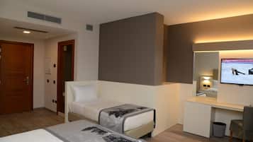 A hotel room with a bed, a desk, a television, and a mirror.