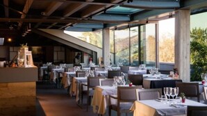 A restaurant with tables set for dining, large windows, and a view of the outdoors. - Albergo Roma, BW Signature Collection (Castelfranco Veneto)