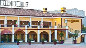 Hotel Eurocongress con techo de teja, ventanas de arco y un balcón con plantas en macetas.
