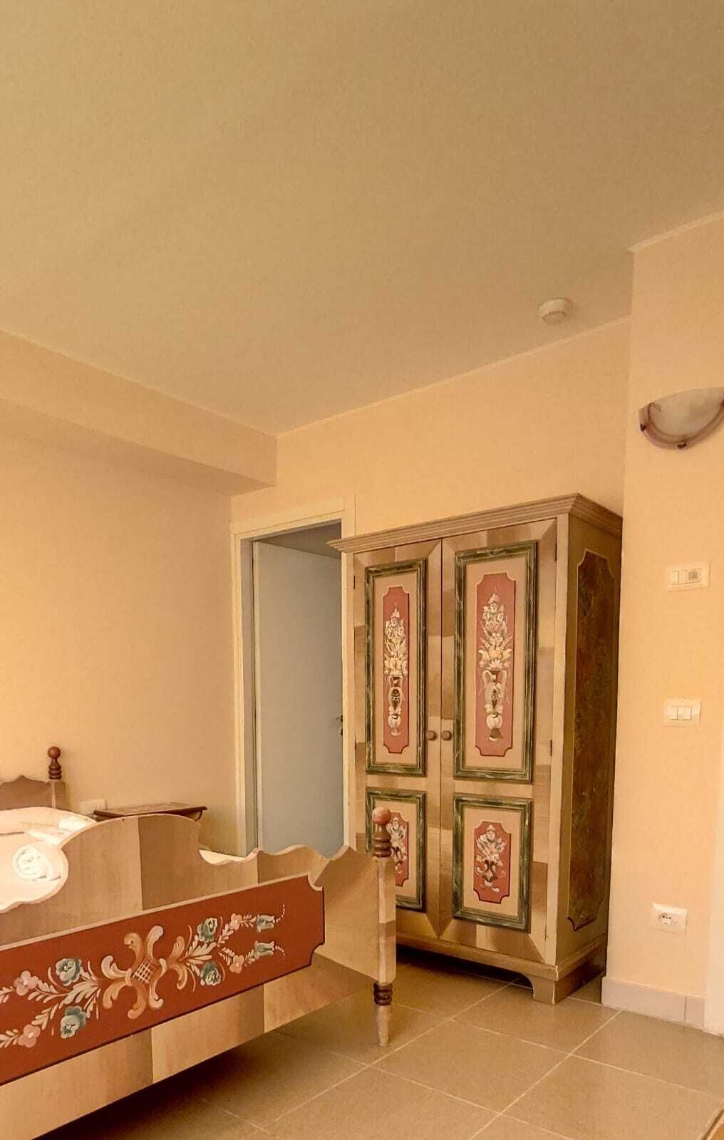 Ein Schlafzimmer mit einem Bett, einem Kleiderschrank und einer Tür.