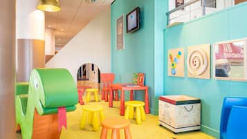 A children's playroom with colorful furniture, a disco ball, and educational toys.