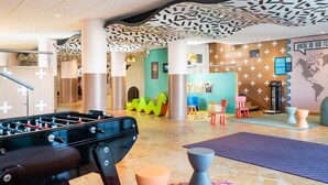A modern lobby with a foosball table, colorful seating, and a unique ceiling design. - Aparthotel Adagio Val d'Europe près de Disneyland Paris (Serris)