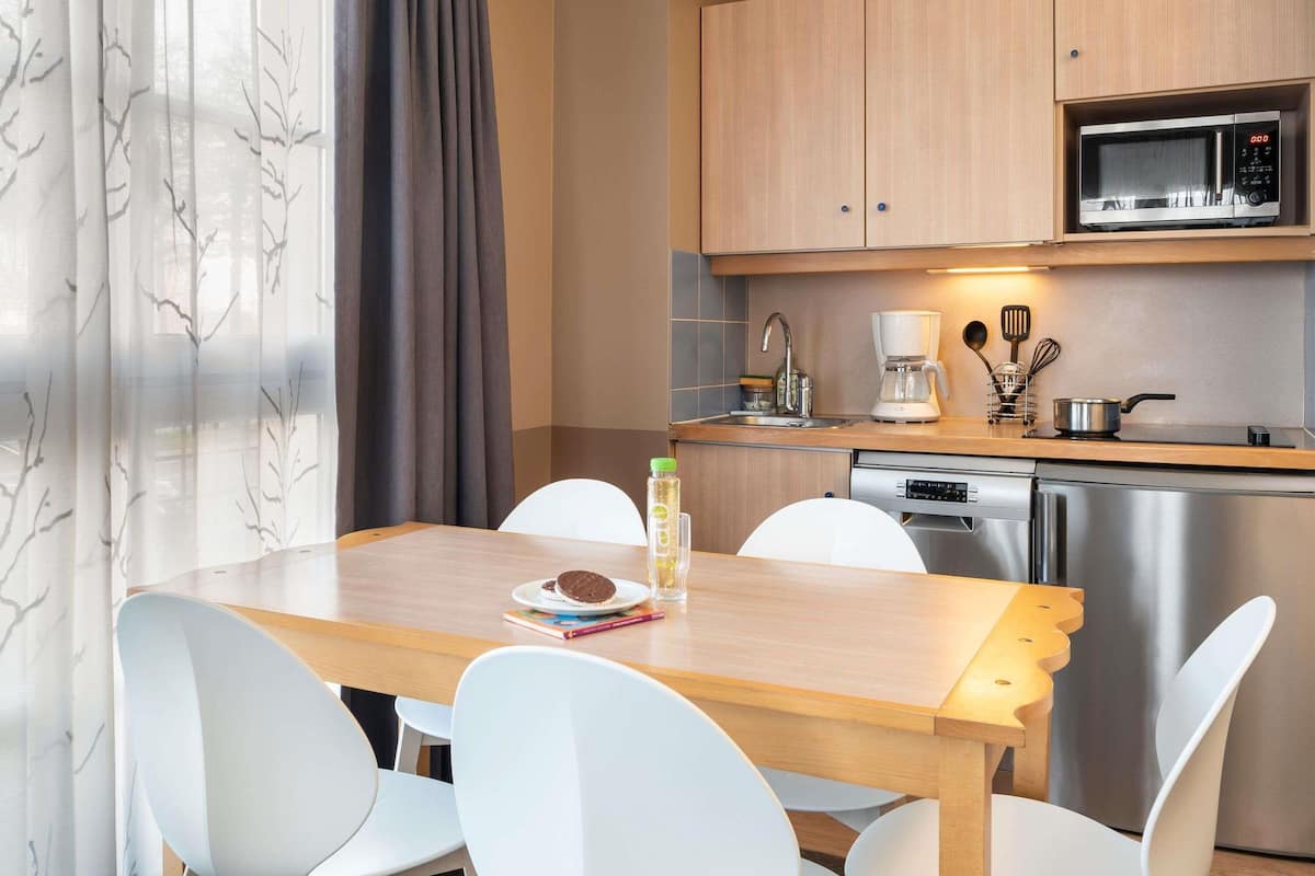 A compact kitchen with a microwave, coffee maker, and dishwasher.