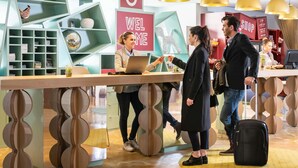 A reception desk with a 'WELCOME' sign, a counter with a laptop, and a modern interior design with geometric shelving and pendant lighting. - Aparthotel Adagio Val d'Europe près de Disneyland Paris (Serris)