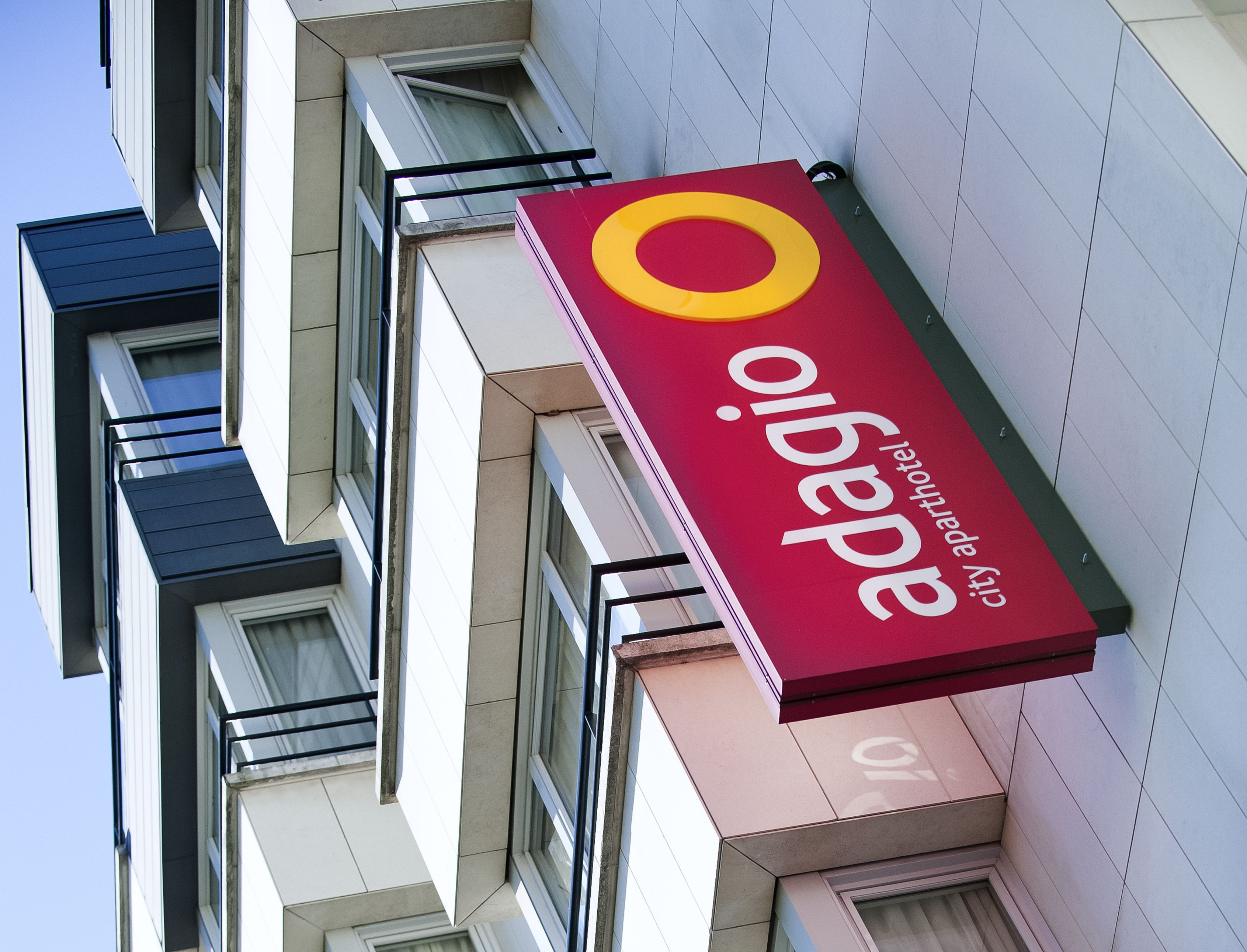 A hotel sign with the name "Opaio" and "city hotel" indicating a modern building with multiple windows and balconies.