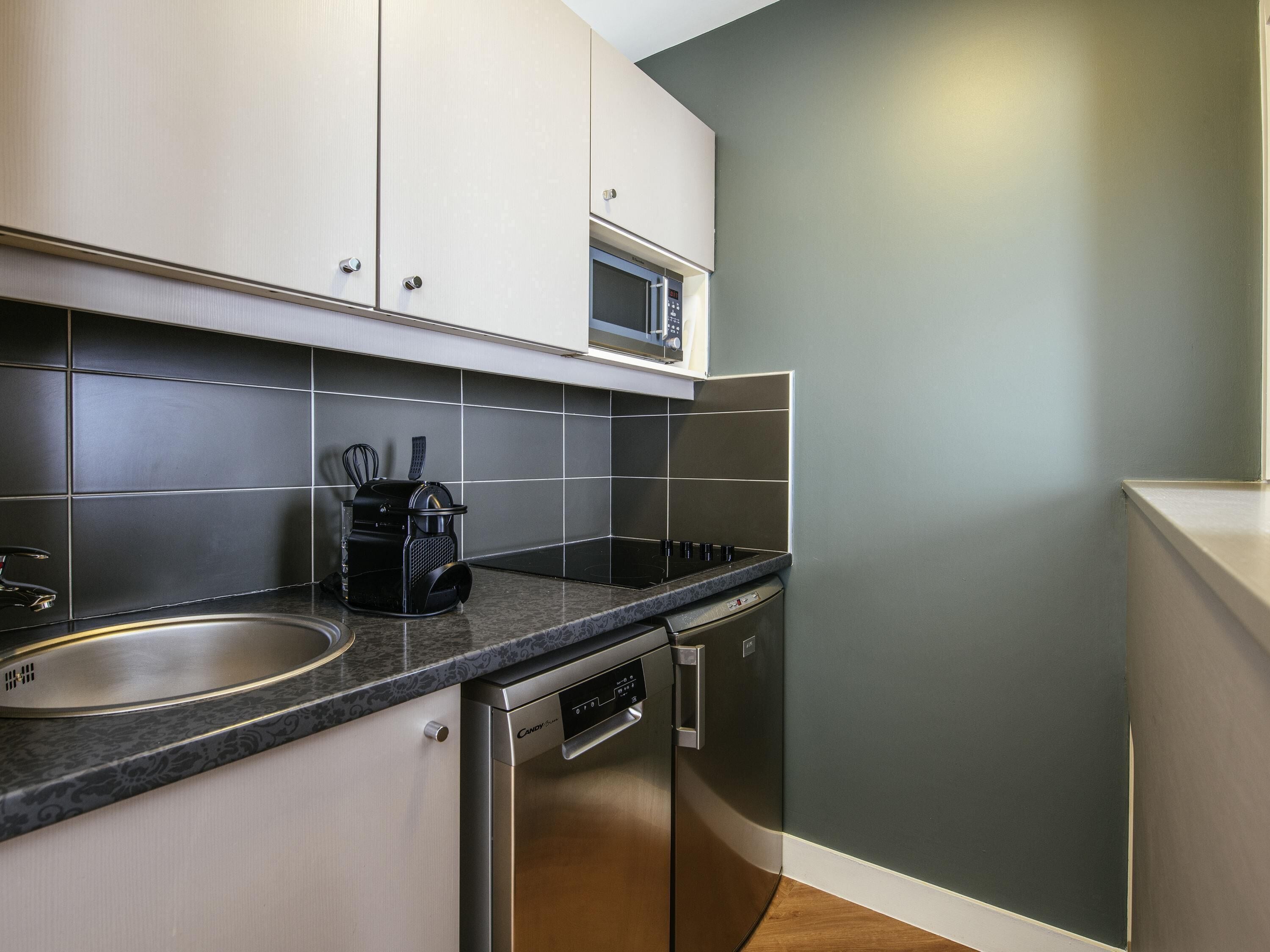 A modern kitchen with stainless steel appliances, a microwave, and a coffee maker.