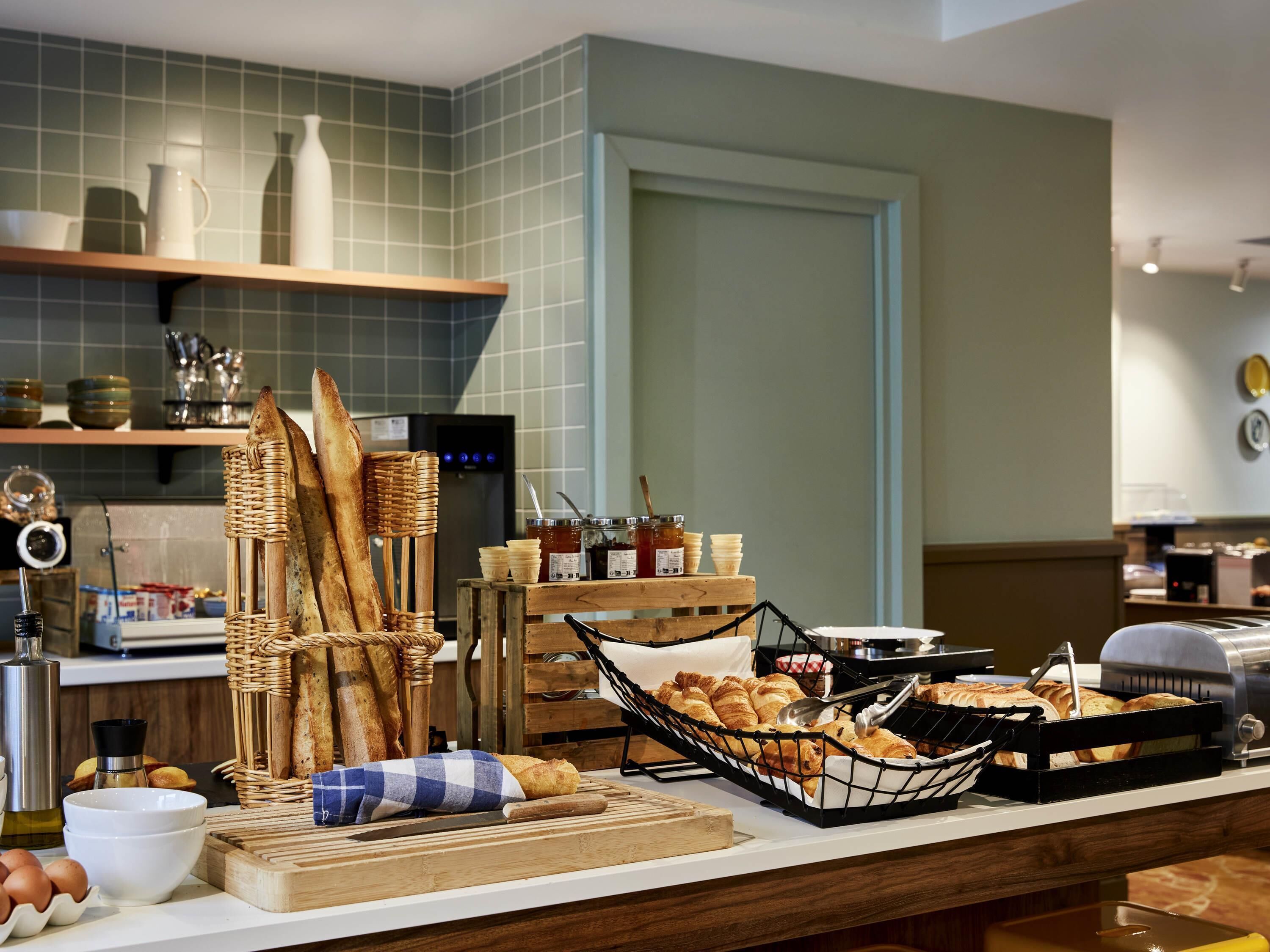 Un buffet de petit-déjeuner comprenant du pain, des viennoiseries et diverses garnitures.
