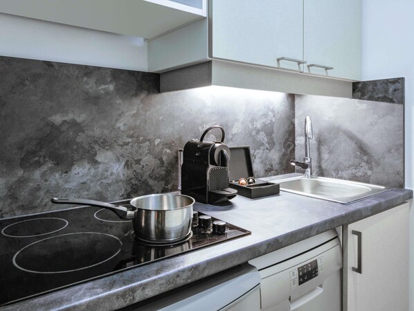 A modern kitchen with a stovetop, a coffee maker, a sink, and a dishwasher. - Aparthotel Adagio Monaco Palais Josephine (Beausoleil)
