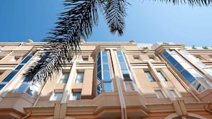 Un edificio de varios pisos con estilo arquitectónico clásico, que presenta amplias ventanas y arcos.