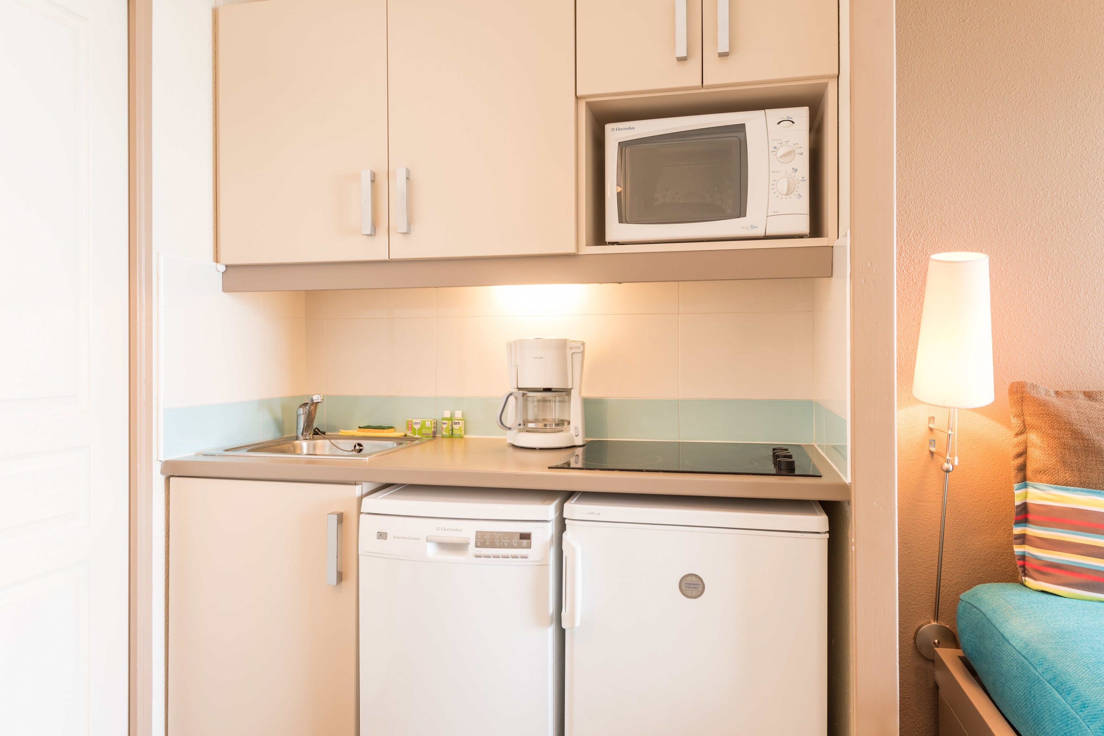 A compact kitchenette with a microwave, coffee maker, and a small refrigerator.