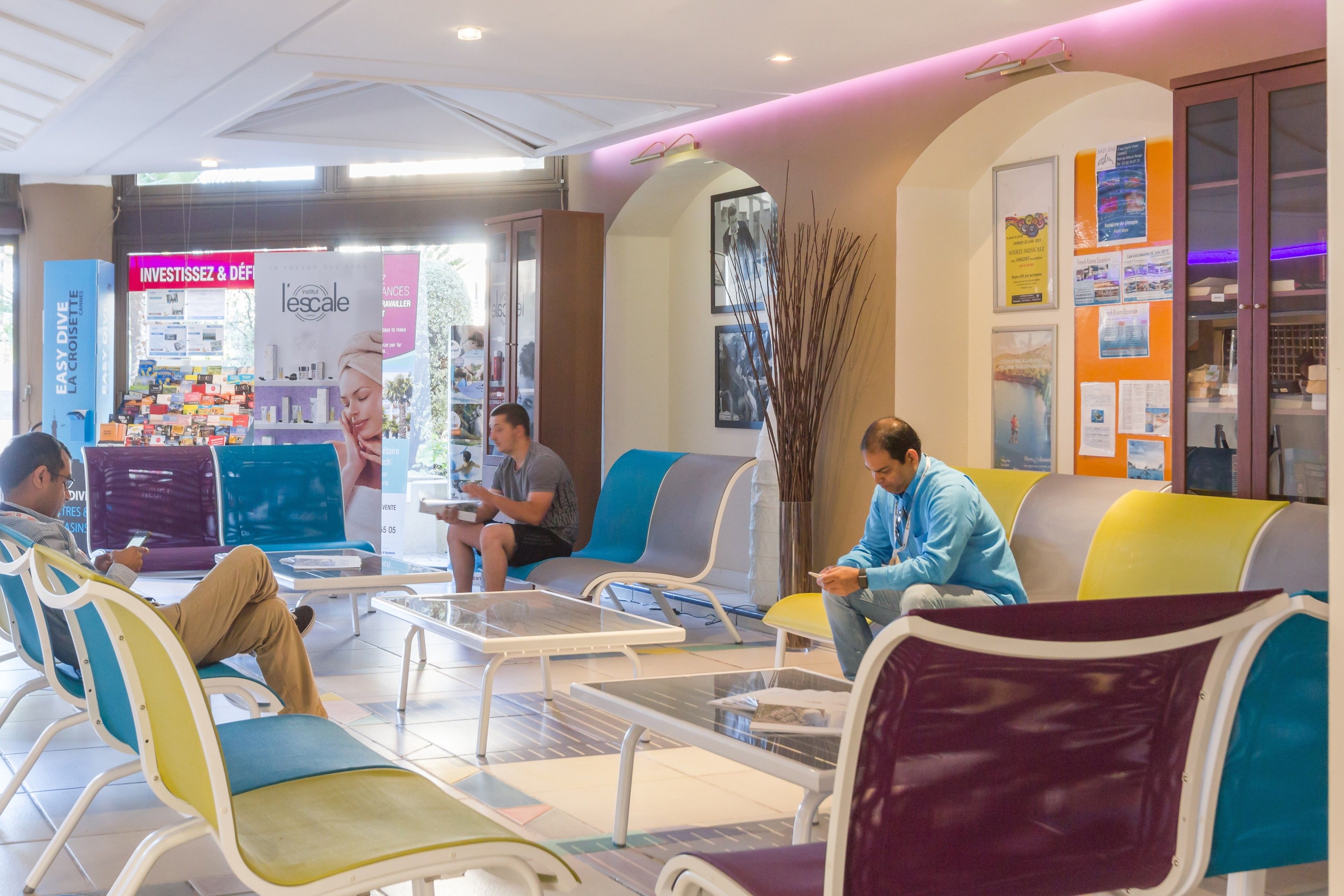 A waiting area with colorful seating, a reception desk, and a visible counter with products.