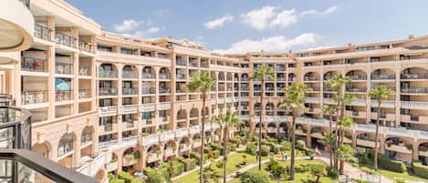 Un hôtel à plusieurs étages doté d’une cour intérieure, de balcons et d’espaces de détente en plein air.