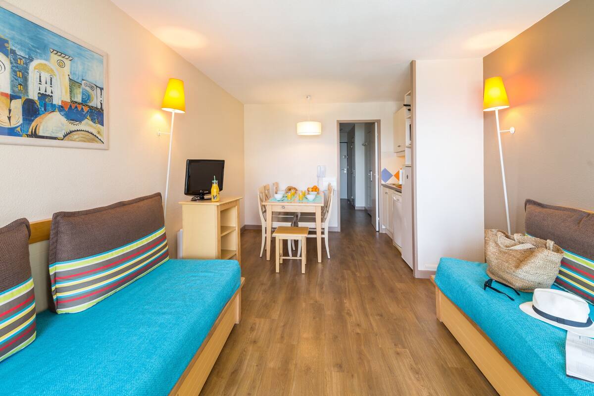 Een hotelkamer met twee bedden, een eettafel en een televisie.