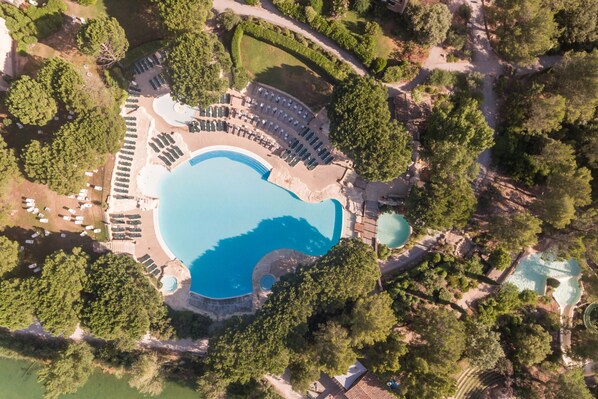 Una piscina al aire libre de temporada, sombrillas, tumbonas