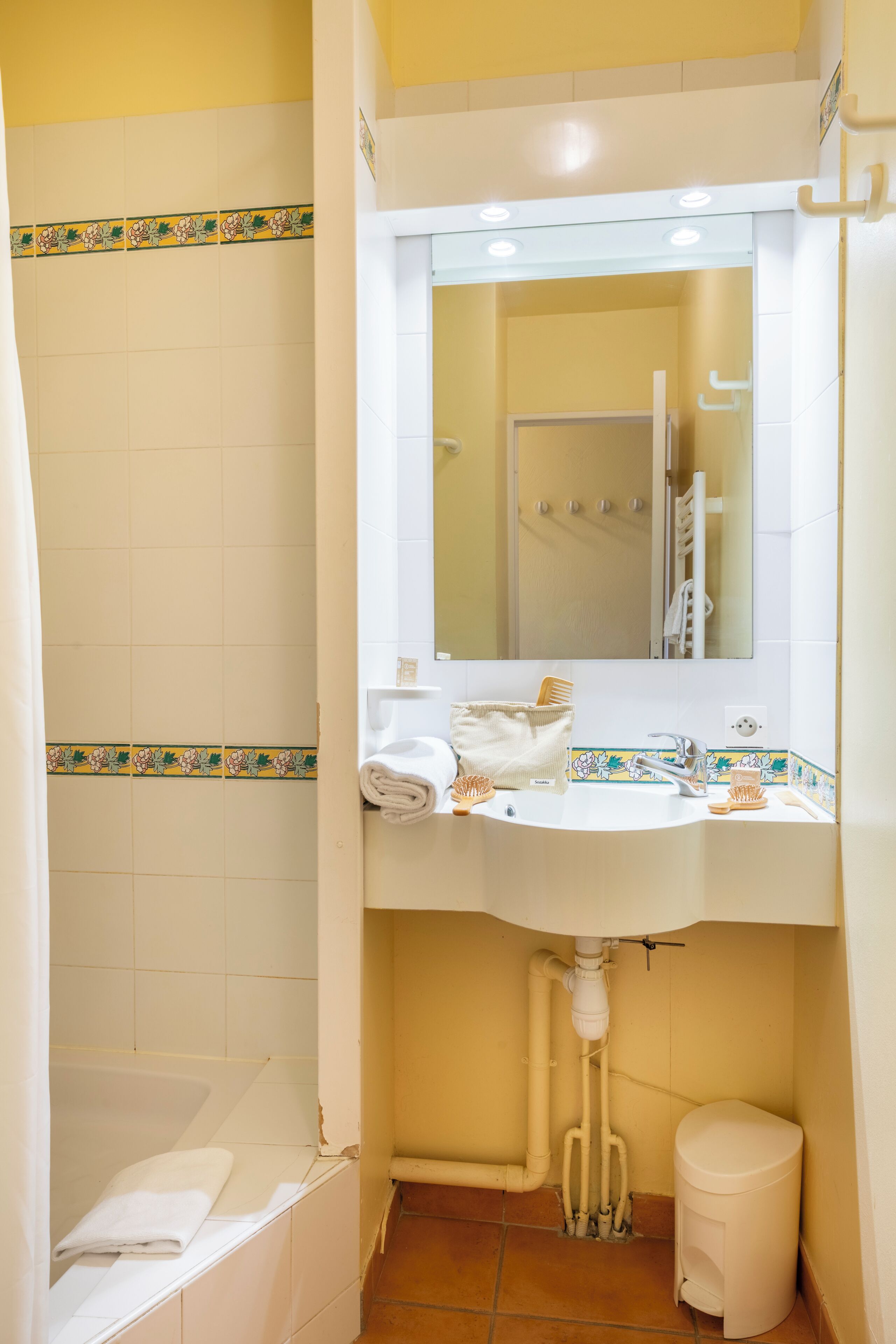 A bathroom with a sink, mirror, and shower.