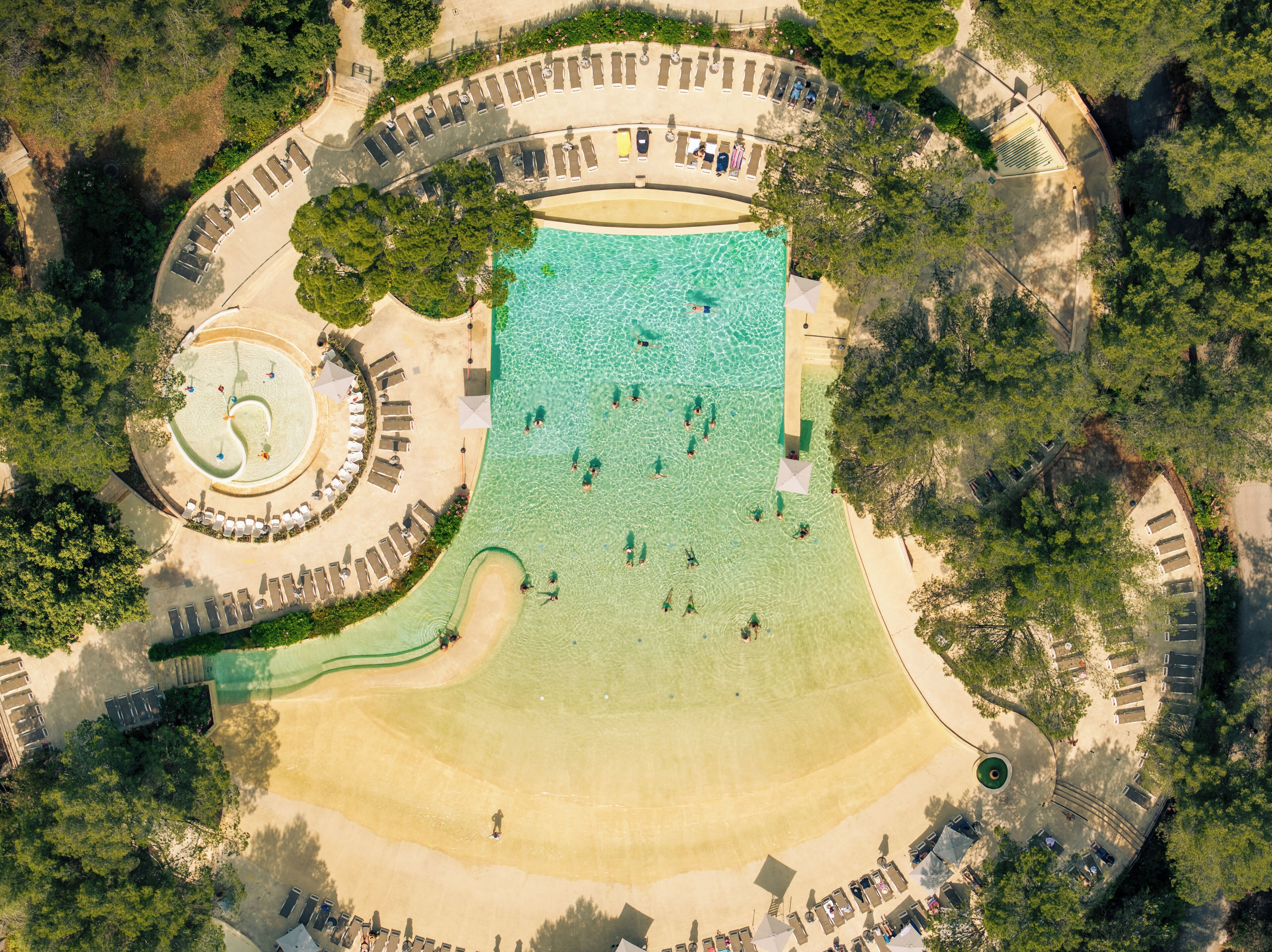 Una piscina al aire libre de temporada, sombrillas