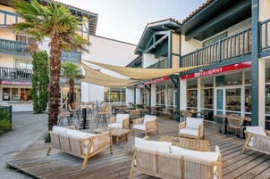 An outdoor seating area with wicker furniture and a wooden deck.