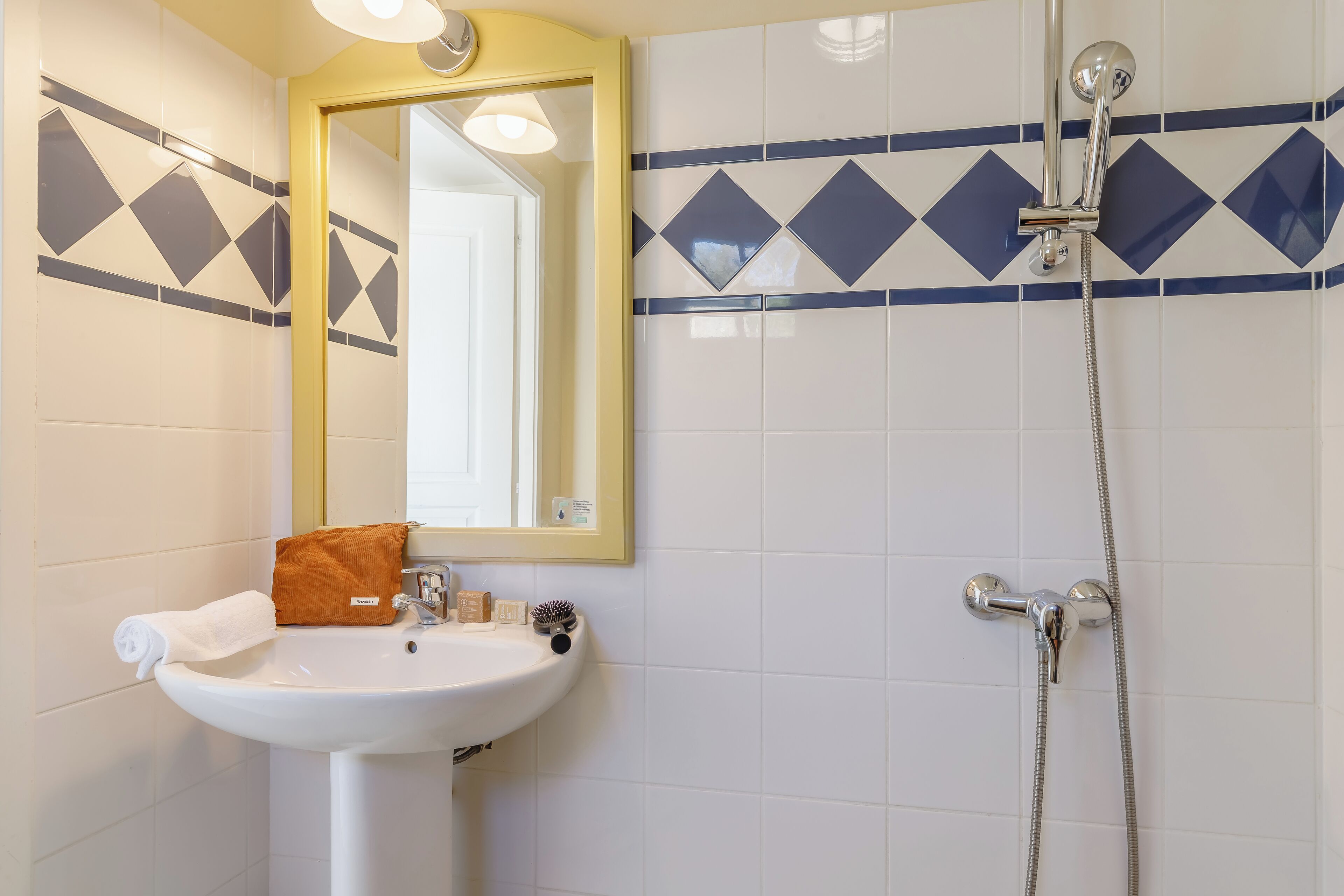 A bathroom with a white sink, a mirror, and a shower.