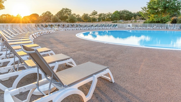 A poolside area with sun loungers arranged in a semi-circle around a pool. - Résidence Pierre & Vacances Le Domaine de Bourgenay (Talmont-Saint-Hilaire)