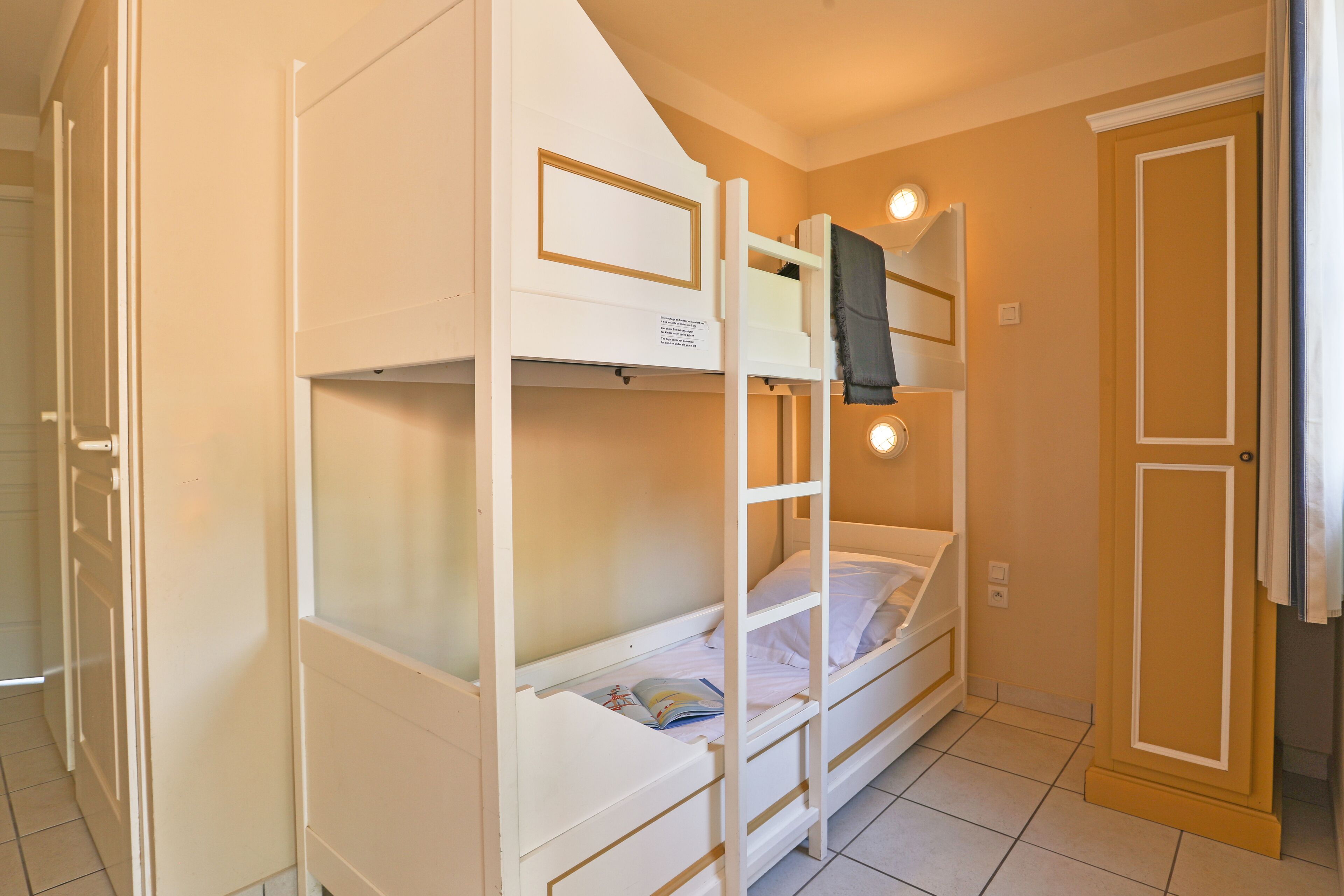 A bunk bed room with a door and a light fixture.