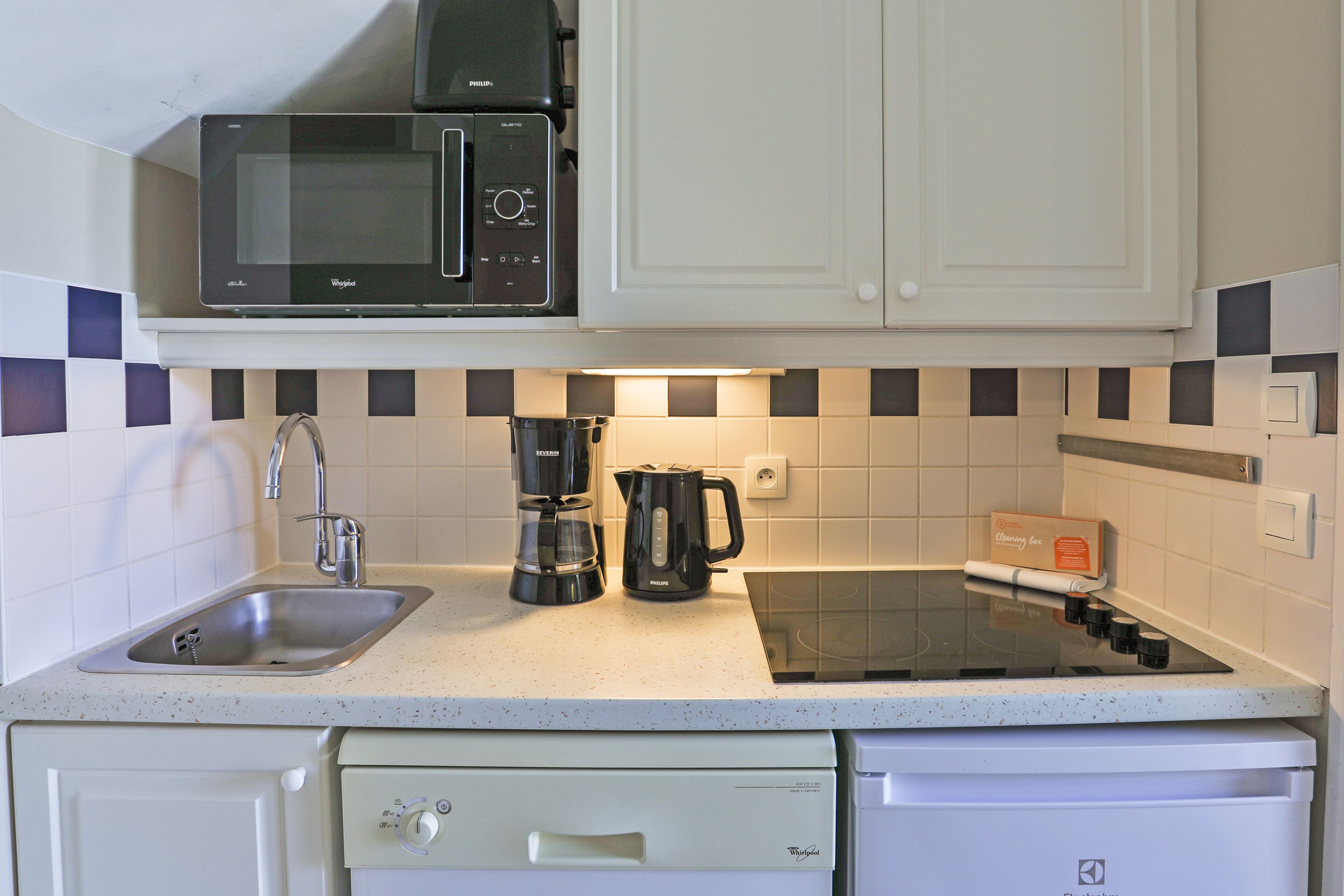 A kitchen with a microwave, coffee maker, and dishwasher.