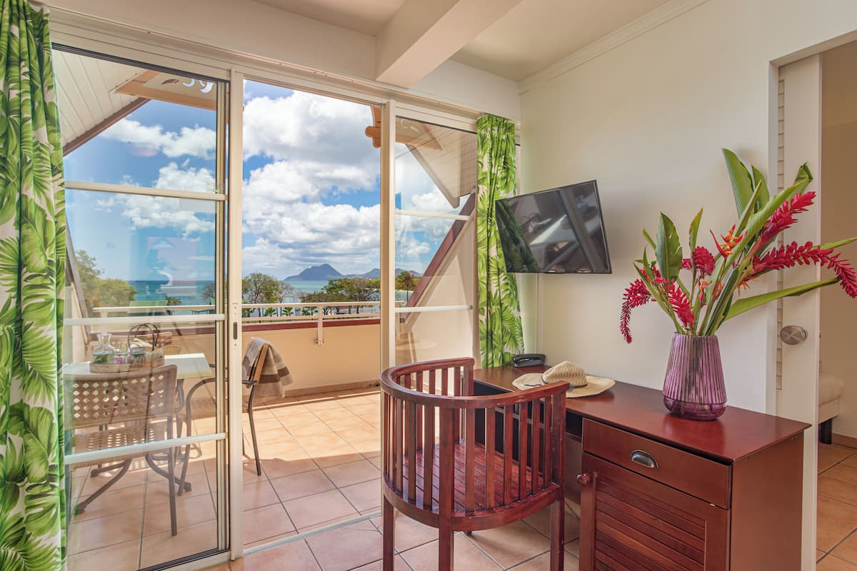 A balcony with a table, chairs, and a TV on the wall.