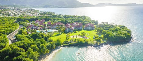 A resort with multiple buildings, a beach, and a large body of water.