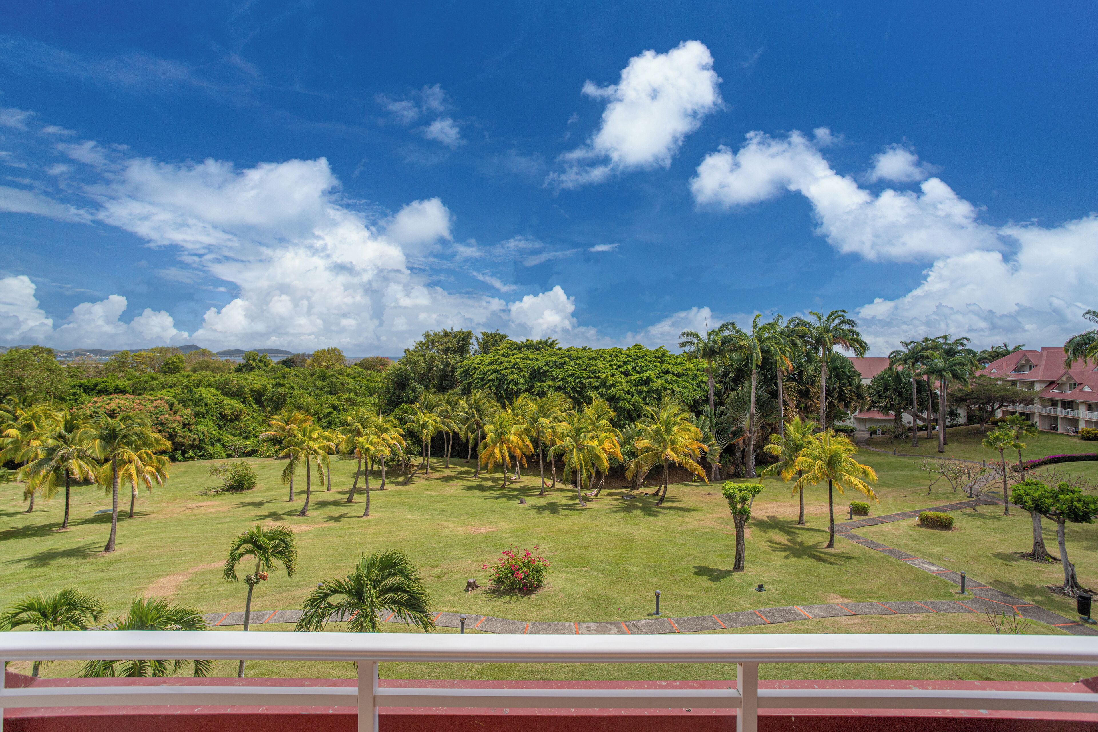 A lush landscape with palm trees and a clear blue sky.