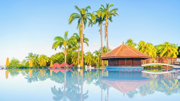 A clear pool with reflections of palm trees and a gazebo. - Village St Luce Pierre & Vacances (Sainte-Luce)