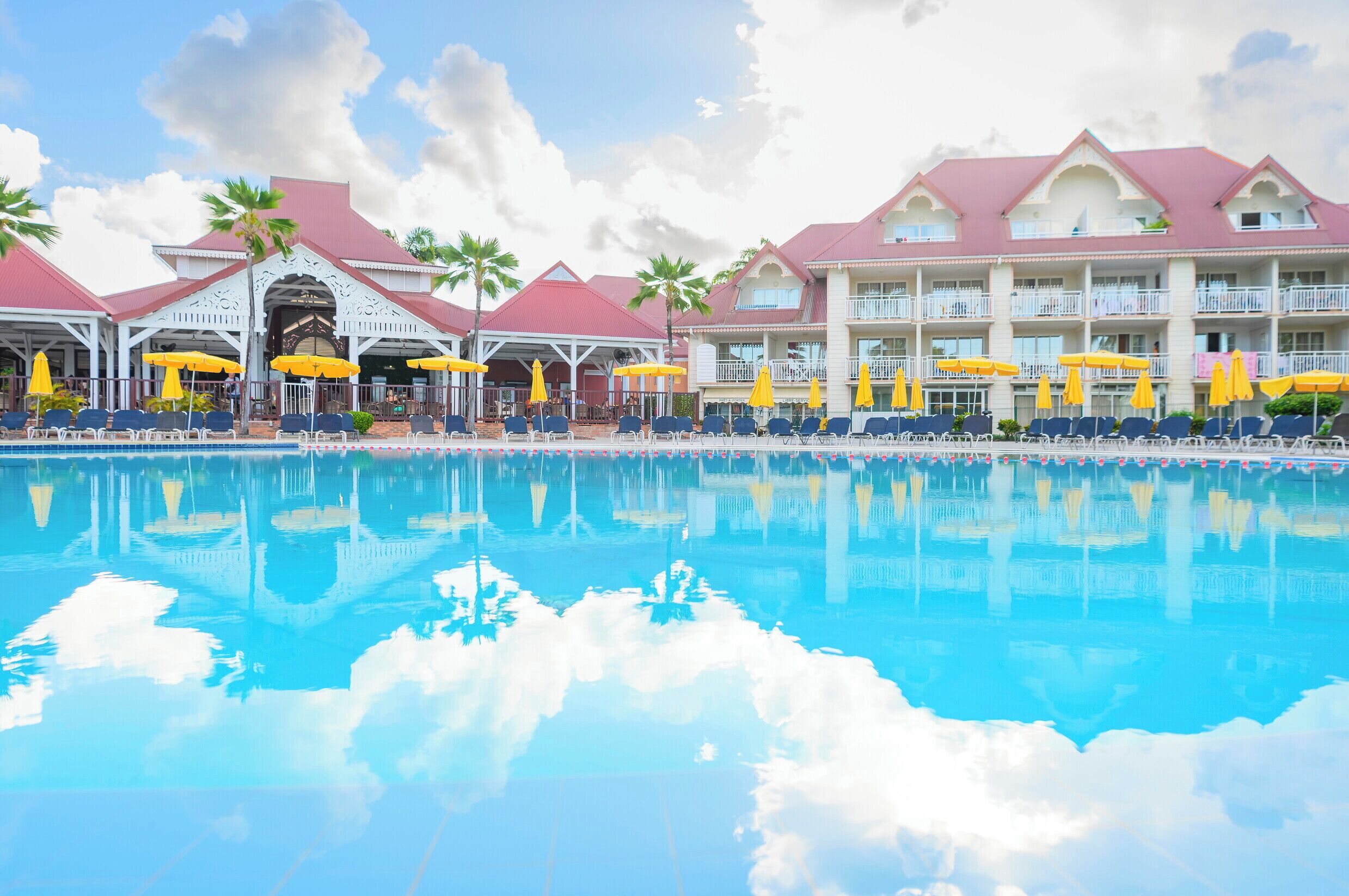 Een buitenzwembad, parasols bij het zwembad en ligstoelen