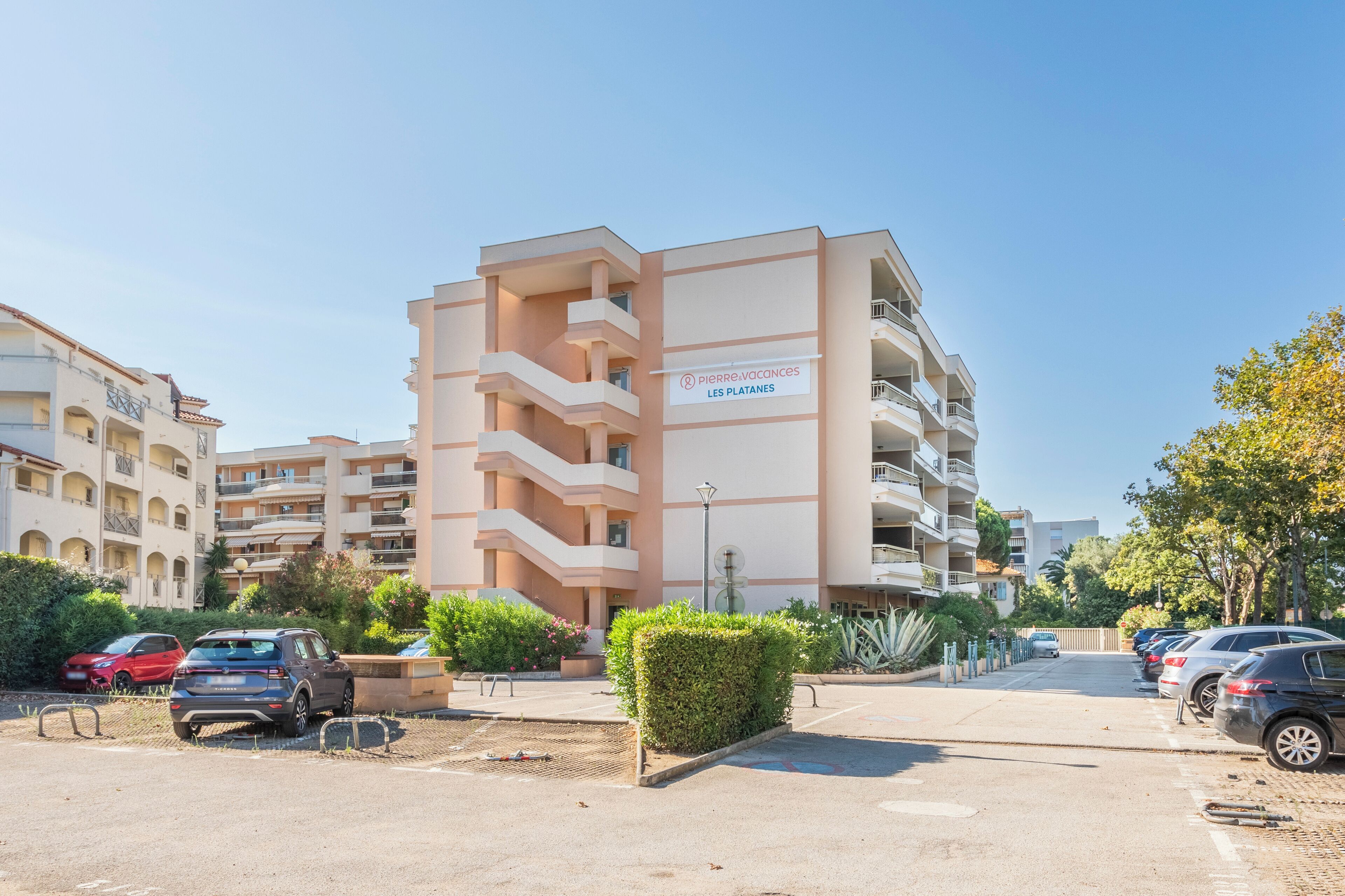 Un hôtel à plusieurs étages, sur lequel on peut lire l’inscription « Pierre & Vacances Les Platanes ».