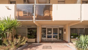 L’entrée d’un hôtel, avec une enseigne indiquant « Pierre & Vacances » et une porte d’entrée en verre.