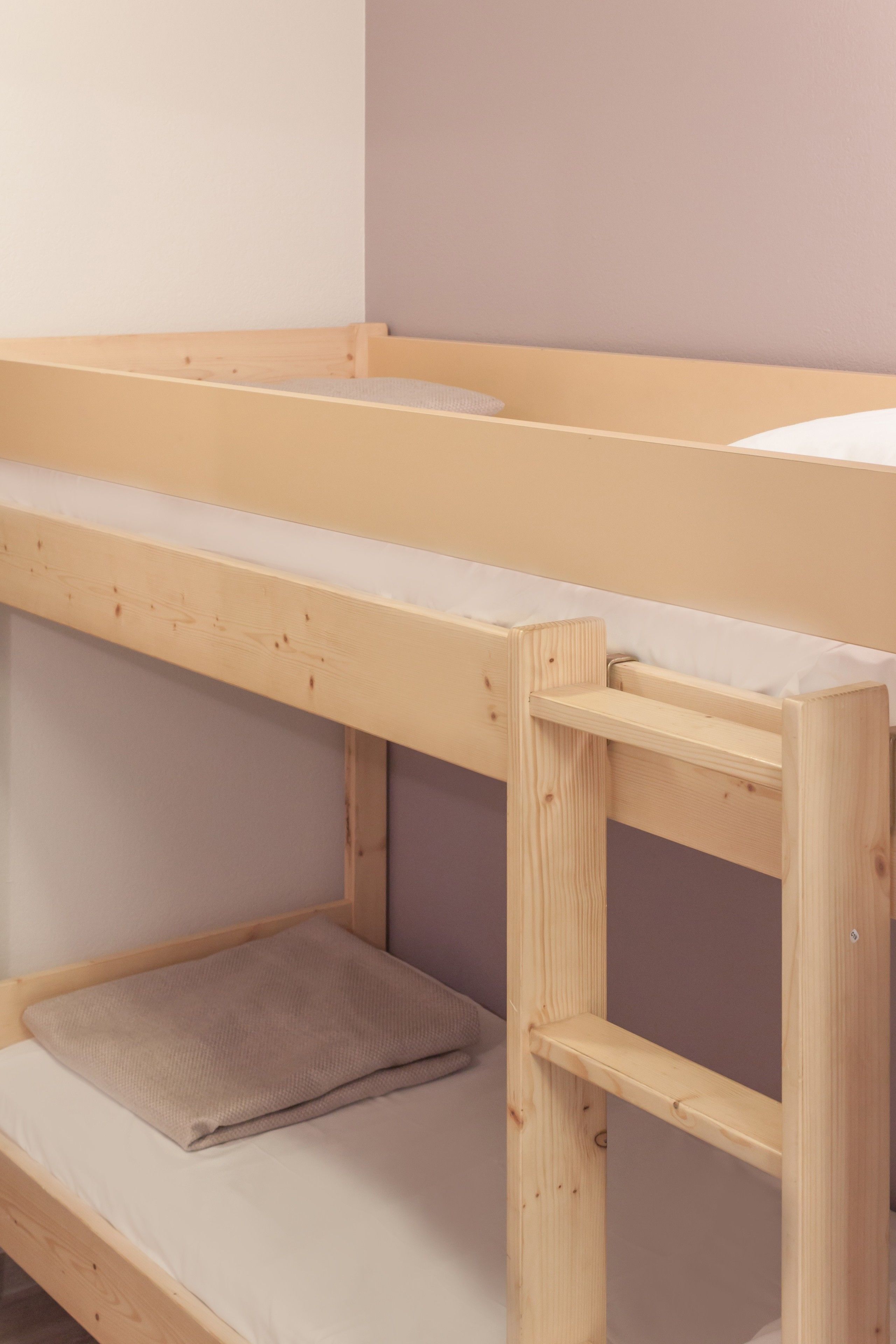 A bunk bed with a wooden frame and a mattress.