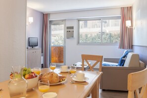 Departamento, 1 habitación | Área de sala de estar | Televisión de pantalla plana y libros 