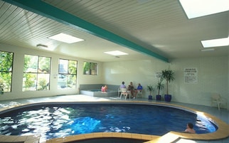 Una piscina techada, sillones reclinables de piscina