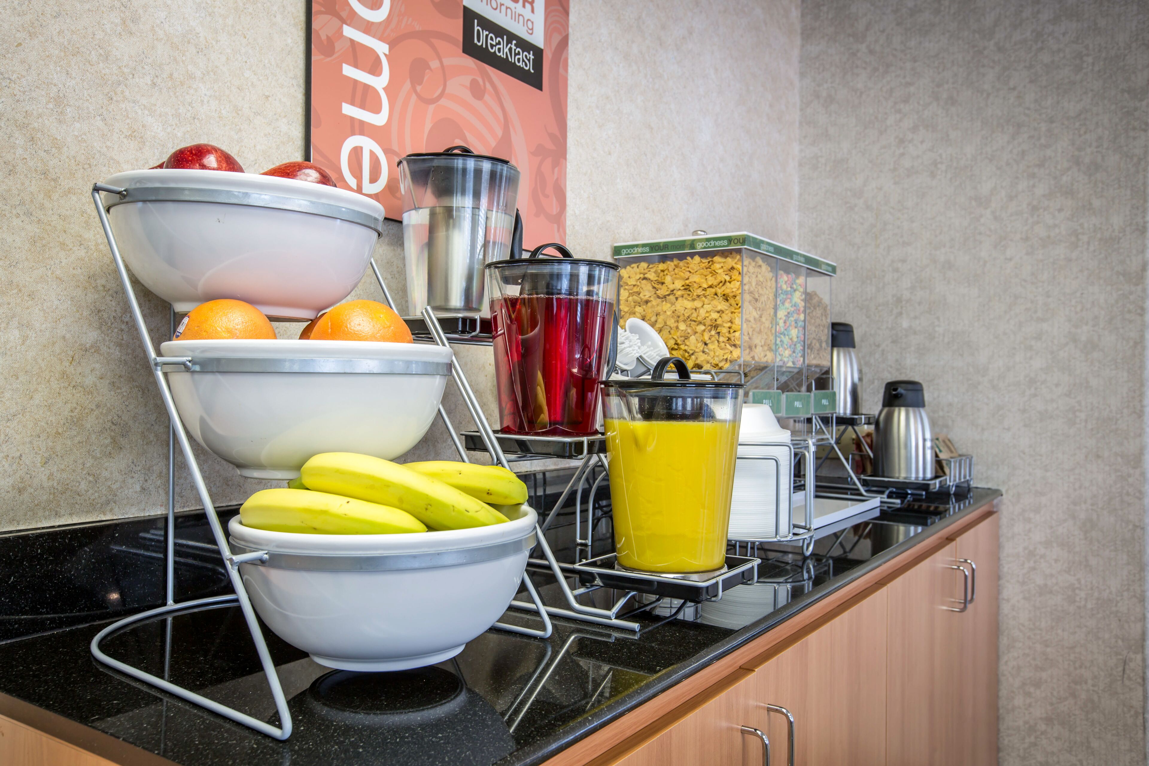 Disposição de buffet de café da manhã com diversos alimentos e bebidas.