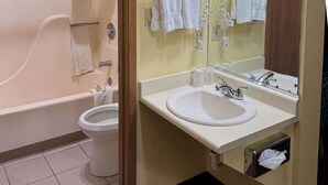 A bathroom with a bathtub, toilet, and sink.