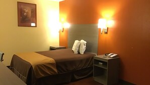 A hotel room with a bed, bedside tables, a lamp, and a telephone.