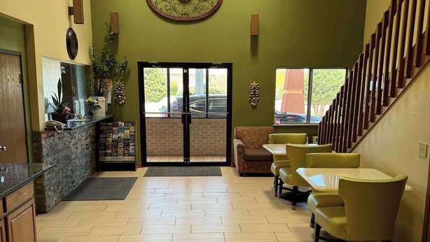 A reception area with a counter, seating, and a staircase.
