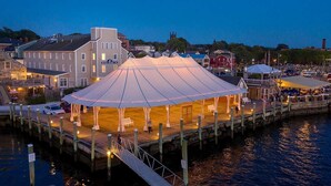 A waterfront pavilion with a covered deck, adjacent to a dock and a building labeled 'Bristol Harbor Inn'. - Bristol Harbor Inn (BRISTOL)