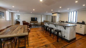 A spacious kitchen with a large island, wooden flooring, and modern appliances. - Bristol Harbor Inn (BRISTOL)