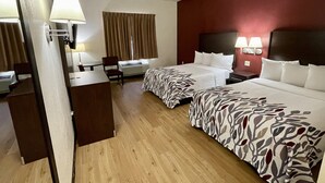 A hotel room with two beds, a desk, a chair, a desk lamp, and a wall-mounted TV. - Red Roof Inn Sandusky - Milan (Milan)