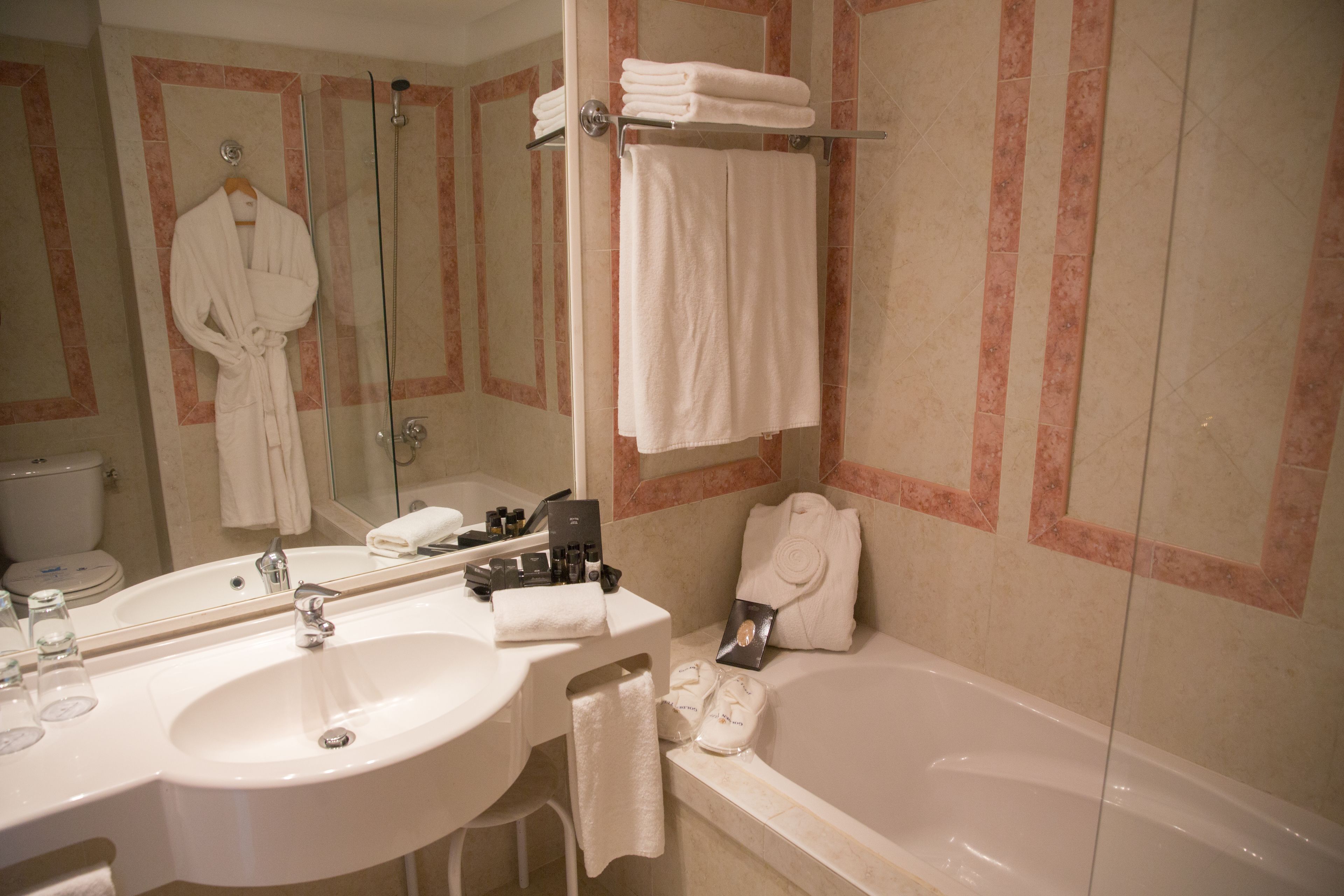 Un baño con lavamanos, espejo y bañera.