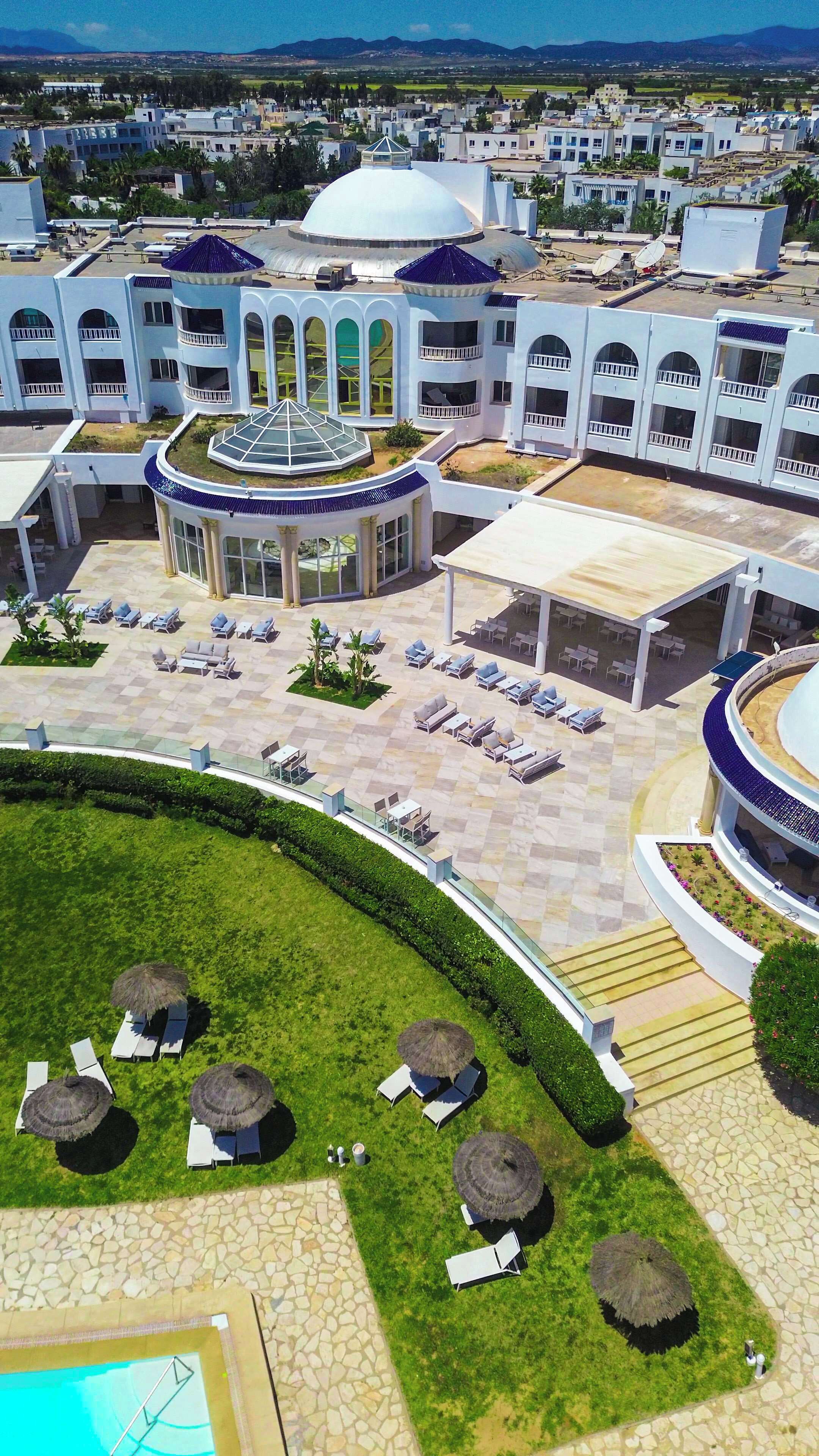 Een hotel met een centrale binnenplaats, loungegedeeltes en een zwembad.
