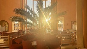 A lobby with a palm tree, seating area, and checkered floor. - Eden Star Resort (Zarzis)