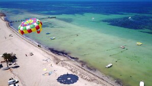 An aerial view of a beach with clear waters, a pier, and several boats. - Eden Star Resort (Zarzis)