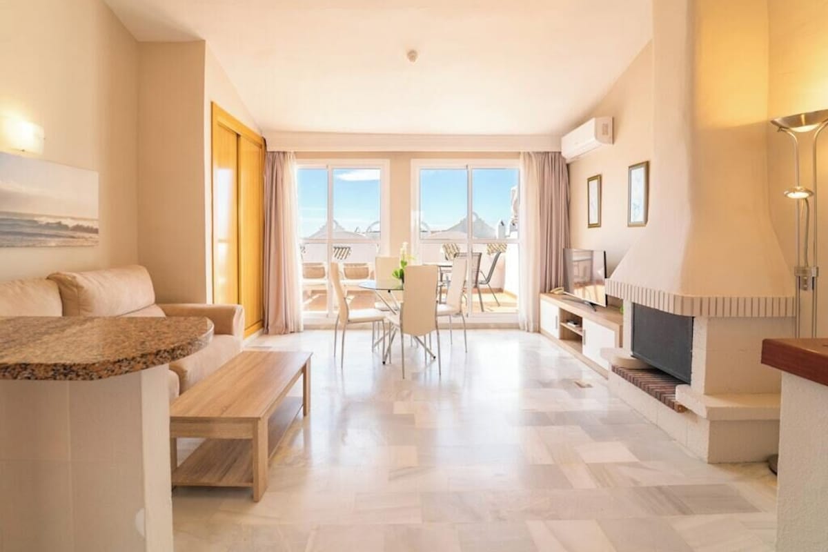 Una sala de estar moderna con sofá, mesa de comedor y televisor.