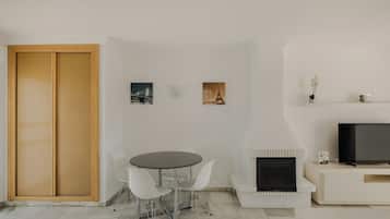 Una sala de estar moderna con comedor, televisor y obras de arte en la pared.